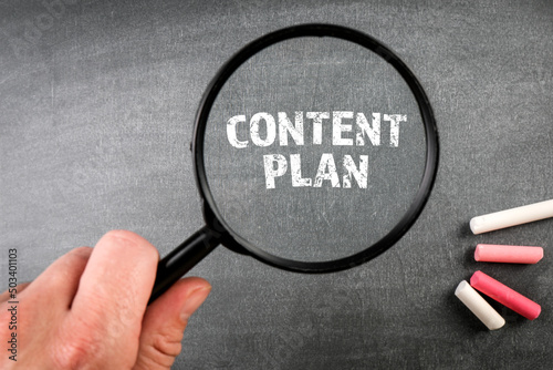 Content Plan. Magnifying glass on a dark chalkboard background