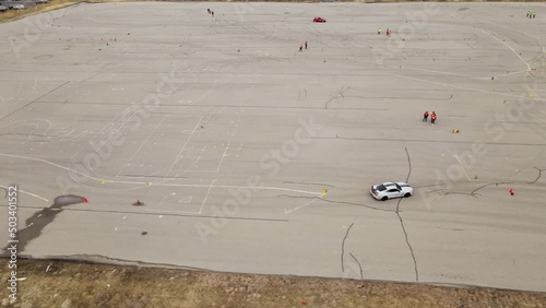 Sport car speeding through course on asphalt, aerial drone view photo