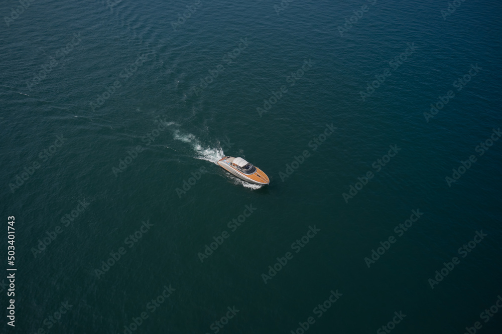 Aerial view luxury motor yacht. Yachts at the sea surface. Travel - image. High-speed yacht of white color  on blue water in the rays of the sun top view.