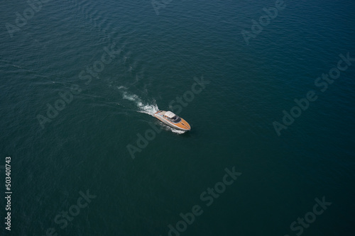 Aerial view luxury motor yacht. Yachts at the sea surface. Travel - image. High-speed yacht of white color  on blue water in the rays of the sun top view. © Berg