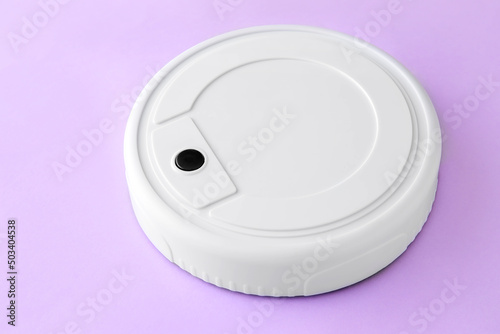 Modern robot vacuum cleaner on lilac background