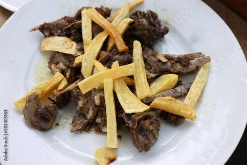 grilled goat with fries on a white plate photo