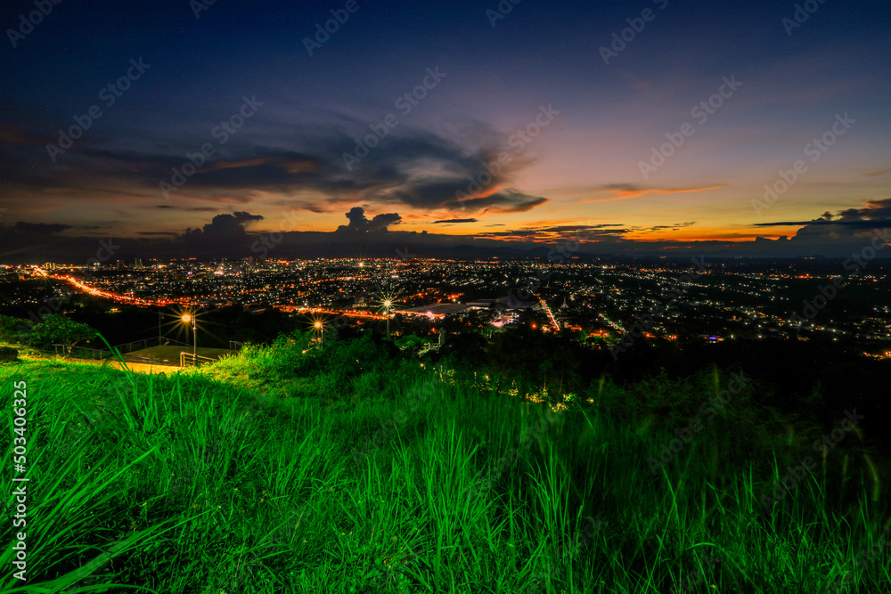 Obraz premium The high angle background of the city view with the secret light of the evening, blurring of night lights, showing the distribution of condominiums, dense homes in the capital community