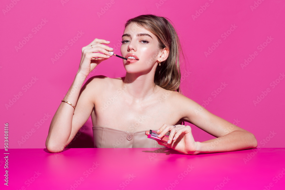 Fashion model applies pink lipstick on lips. Makeup, applies cosmetics. Beautiful woman face. Make up in process. Fashion model applies pink lipstick on lips. Makeup, applies cosmetics. Beautiful woman face. Make up in process.