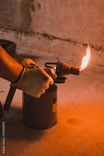 Gasoline blowtorch with a burning fire, the use of a blowtorch in construction. photo