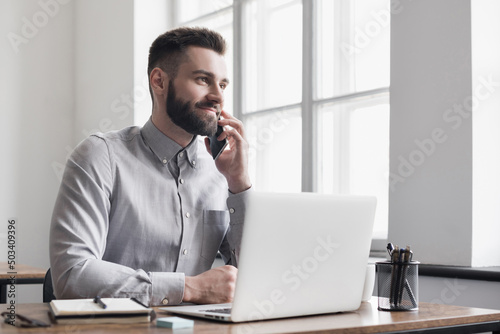 Businessman using laptop computer in office. Young man entrepreneur working at home. Online learning, internet marketing, business studying, working from home, education, web conferencing concept