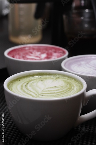 Warm hot matcha and taro latte in a mug