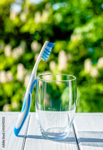 Toothbrush stands in a glass on a natural background