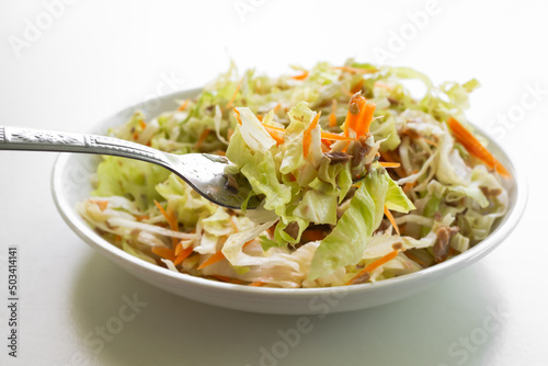 Cabbage,carrot with tuna salad. cooking vegetable salad in white plate on white background. food diet and control weight for good health.