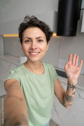 Smiling woman taking selfie at home photo