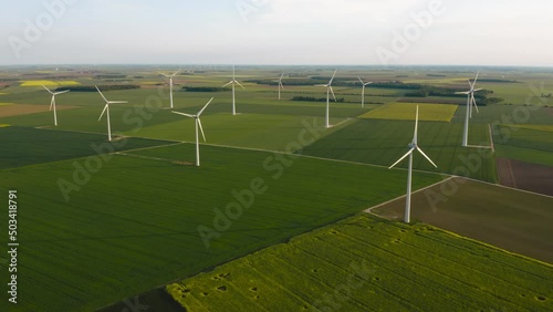 Solar power plant and Windmills aerial view. Renewable energy. Green tech. Farm windmills at sunset. Wind turbines power farm Future technology. Wind power turbines generating. Aerial. Drone. 4K.  photo