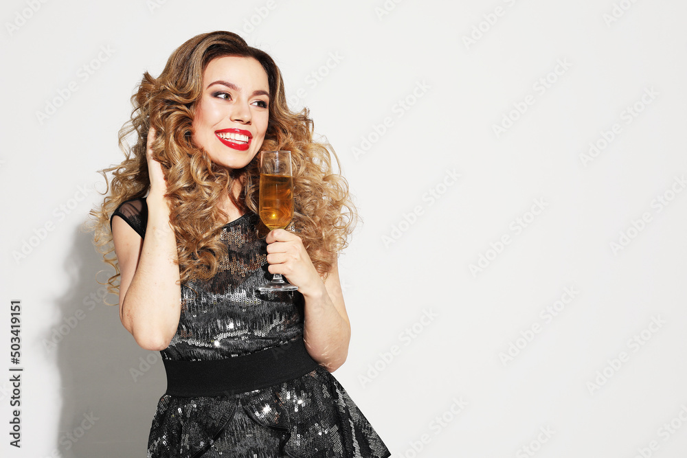 New Year, Birthday, holiday concept: Young attractive woman in evening dress holding glass of champagne New Year, Birthday, holiday concept: Young attractive woman in evening dress holding glass of champagne