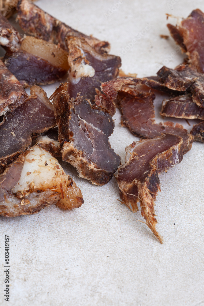 South African Biltong, a dried and cured meat sliced and on grey backdrop with copy space South African Biltong, a dried and cured meat sliced and on grey backdrop with copy space