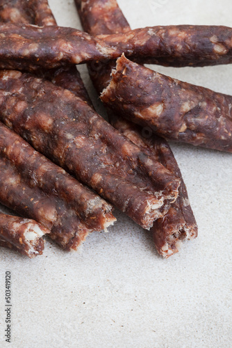 South African Dry Wors, a dried and cured sausage snack on grey, with copy space