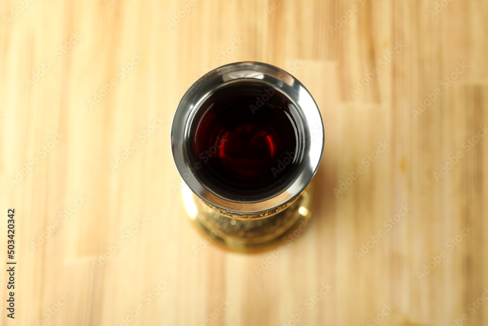 Concept of Eucharist with Chalice on wooden background