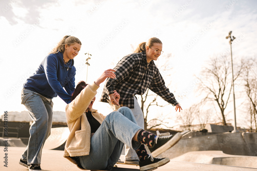 Teenage girls skateboarding in skatepark Teenage girls skateboarding in skatepark