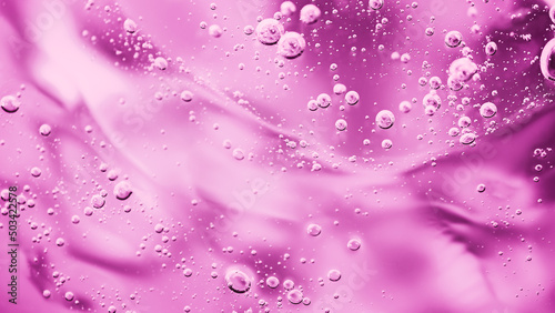 Close up macro Aloe vera gel cosmetic texture pink background with bubbles. Lemongrass gel skincare product. antibacterial liquid with aloe vera, moisturizing. Safe and environmental friendly.