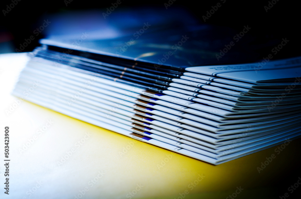 stack of magazines on yellow background, isolated