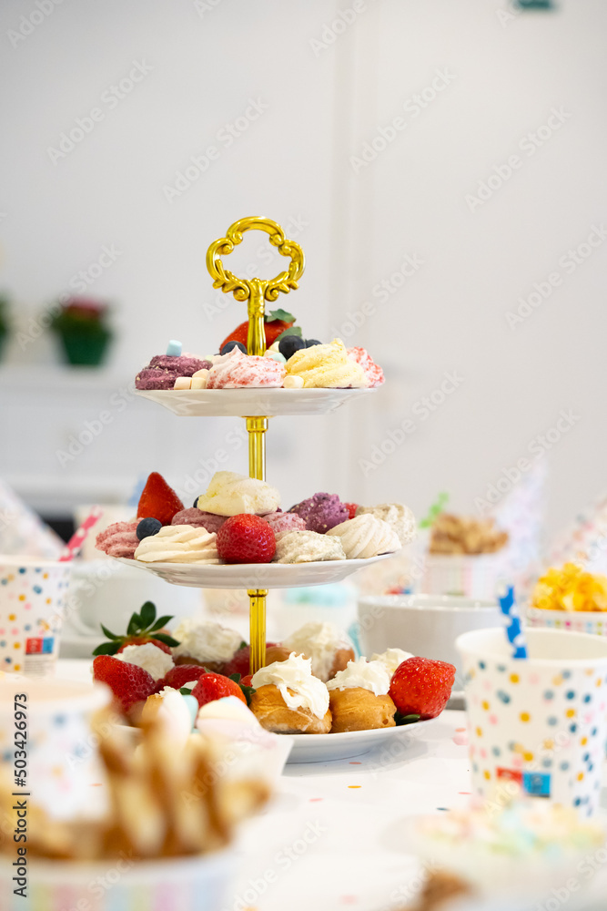Cake, Candy, Marshmallows, Fruits and Berries, Chocolates, Waffles and other Sweets on Dessert Table at Kids Birthday Party Cake, Candy, Marshmallows, Fruits and Berries, Chocolates, Waffles and other Sweets on Dessert Table at Kids Birthday Party