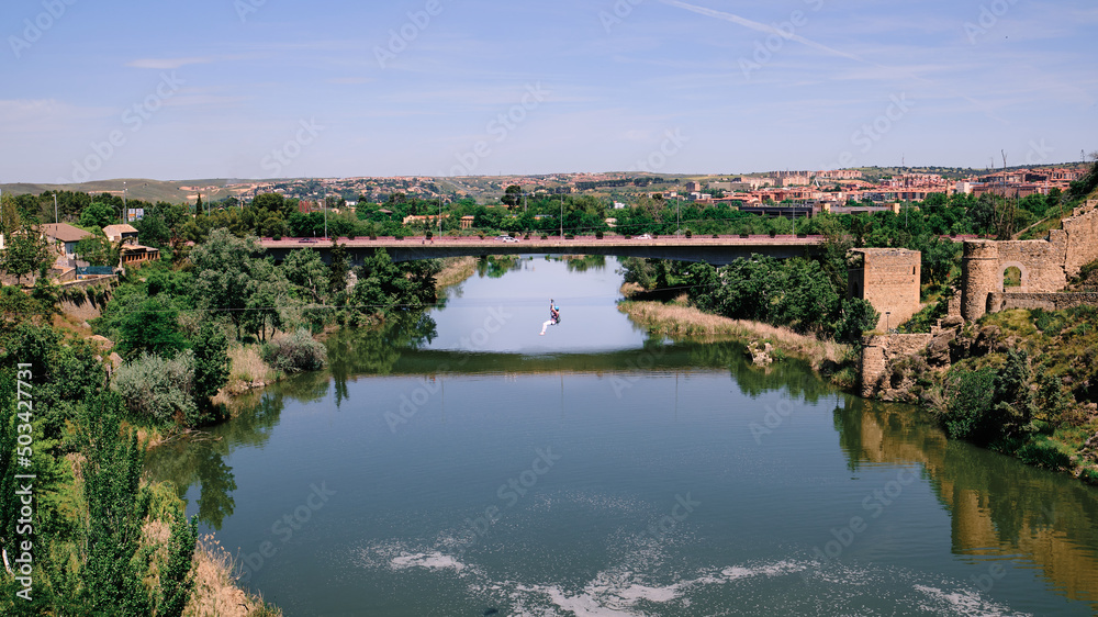 Person jumping on a zip line across the Tajo river in Toledo