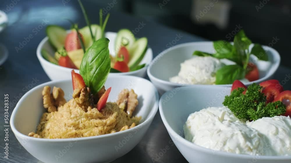 Close-up Professional Chef at Restaurant Kitchen Serves Dish Adding Final Ingredient by Hand. Preparing Meal Kitchen Slow motion,4K.1 Close-up Professional Chef at Restaurant Kitchen Serves Dish Adding Final Ingredient by Hand. Preparing Meal Kitchen Slow motion,4K.1
