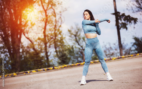Portrait of beautiful fit woman exercising in the park. Caucasian female fitness model working out in the morning.