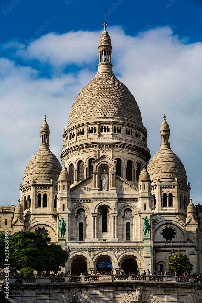 Front view of the Basilica of the Sacré-Coeur in the Parisian district of Montmartre on a sunny day with white clouds in the sky. Front view of the Basilica of the Sacré-Coeur in the Parisian district of Montmartre on a sunny day with white clouds in the sky.