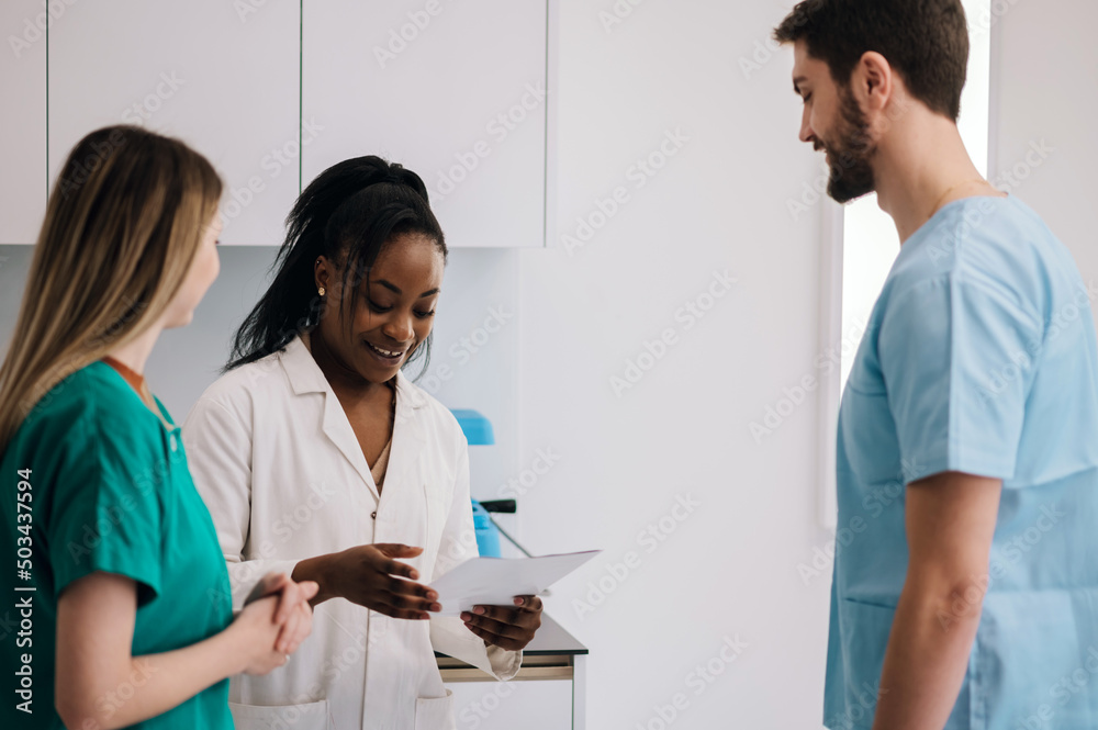 Multiracial team of doctors discussing a patients condition while working in a hospital Multiracial team of doctors discussing a patients condition while working in a hospital