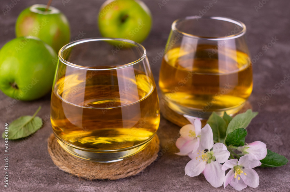 Two glasses with fresh apple juice on a gray background.
Two glasses with fresh apple juice on a gray background.