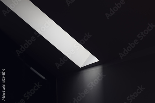 Dark room with strip of light coming from the roof window as abstract background photo