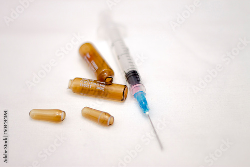 Empty medical ampoules infusion and used syringe after vaccination isolated on white background
