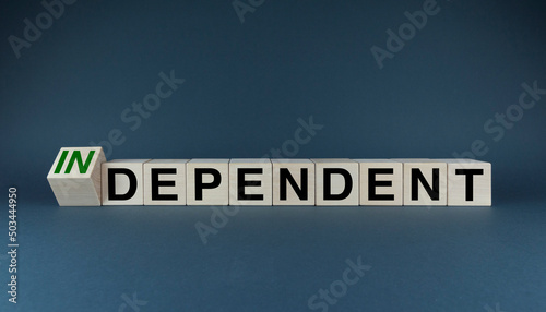 Cubes form the words Independent or dependent. The concept of independence in business, international relations and personal life photo