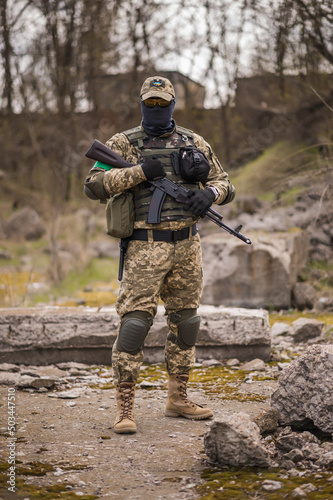 Soldier of the Armed Forces of Ukraine. Military man in tactical uniform with a machine gun in his hands