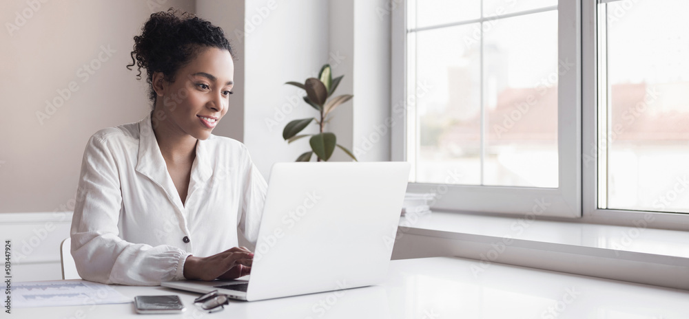 Young woman using laptop computer at office. Student girl working at home banner. Work or study from home, freelance, business, lifestyle concept Young woman using laptop computer at office. Student girl working at home banner. Work or study from home, freelance, business, lifestyle concept