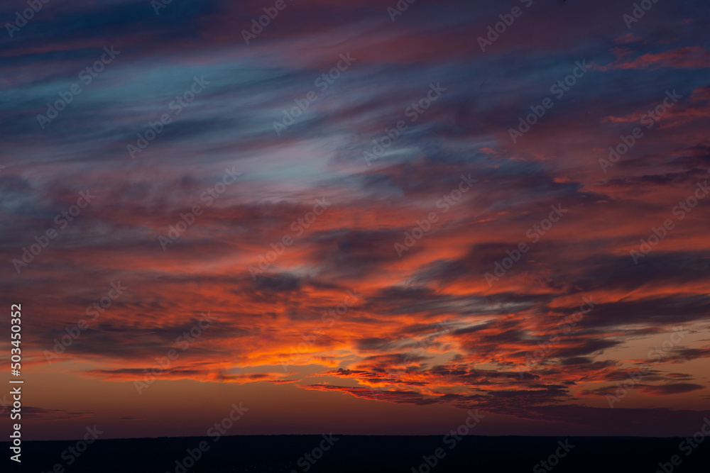 A beautiful orange sunset with clouds over the horizon