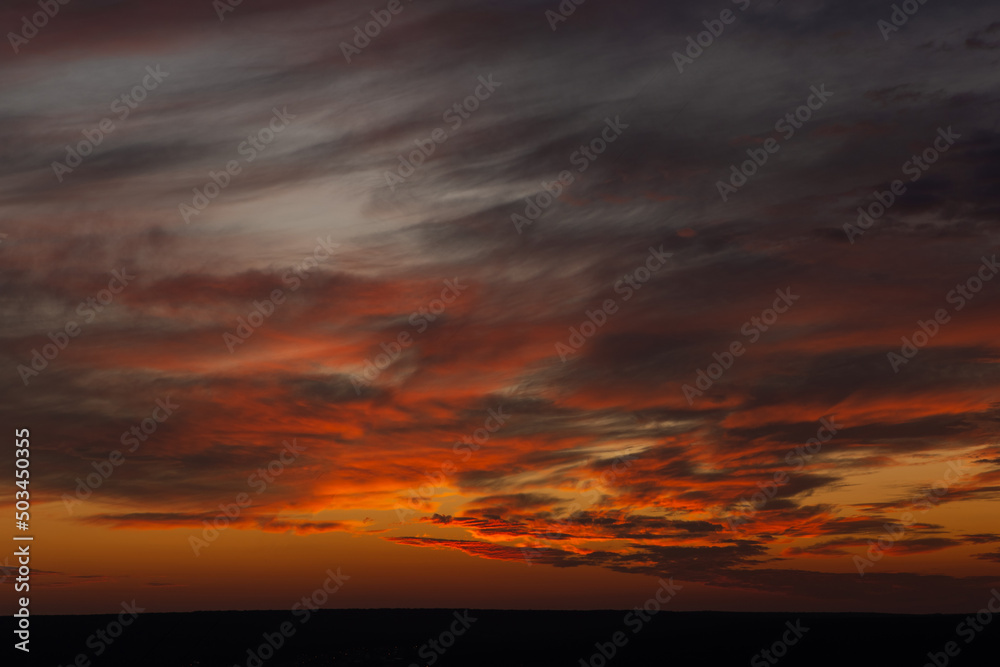 A beautiful orange sunset with clouds over the horizon