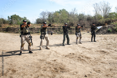 Group of army soldiers practice gun shooting on target photo