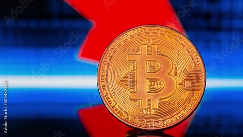 Close up photo of golden shiny litecoin standing on the background with digital colorful candle graphs showing falling of the crypto currency