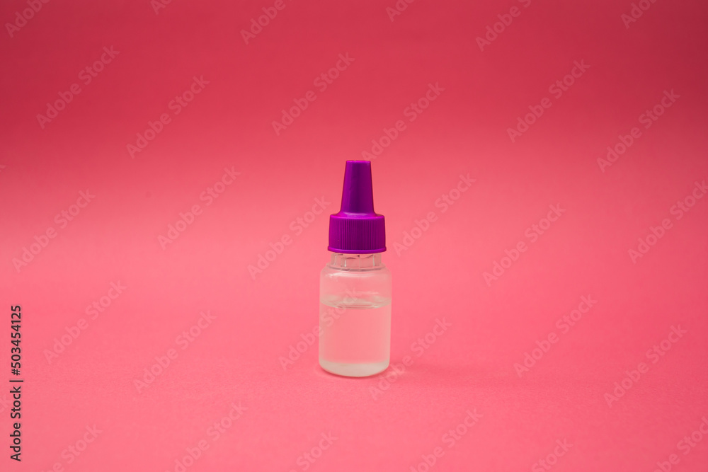 A small cosmetic bottle on a pink background A small cosmetic bottle on a pink background