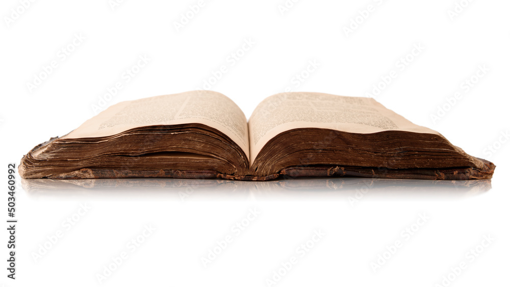 Single old worn jewish book. Open pages of Torah isolated on white background with reflection. Closeup. Selective focus.