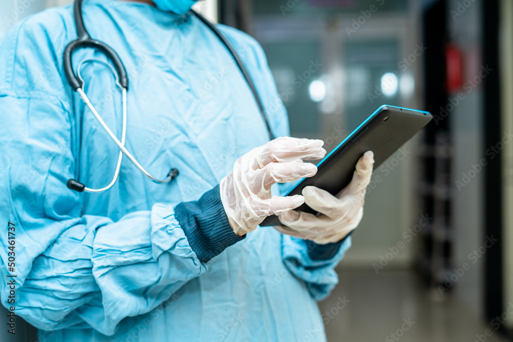 Close up shot of surgeon hands using smart tablet at hospital corridor - concept of checking reports, technologyand healthcare or medical treatment Close up shot of surgeon hands using smart tablet at hospital corridor - concept of checking reports, technologyand healthcare or medical treatment