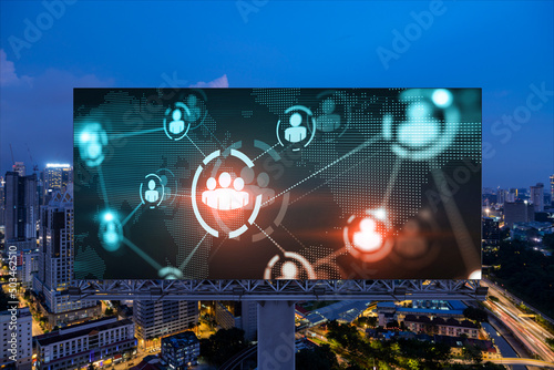 World planet Earth map hologram and social media icons on billboard over night panoramic city view of Kuala Lumpur, Malaysia, Asia. Networking and establishing new connections between people. Globe photo