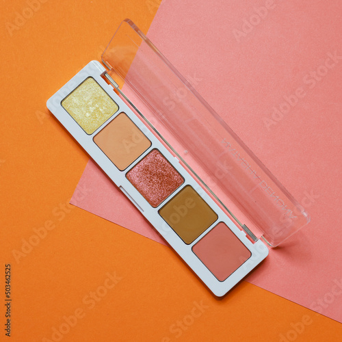 Colorful eyeshadow makeup palette. Realistic image with matte, glitter, multichrome pigments. Shadows set in vibrant colorful scheme. Top view flat lay package isolated on colorful background.