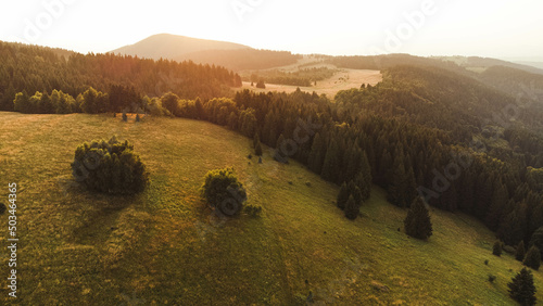 sunset in mountains and trees from drone