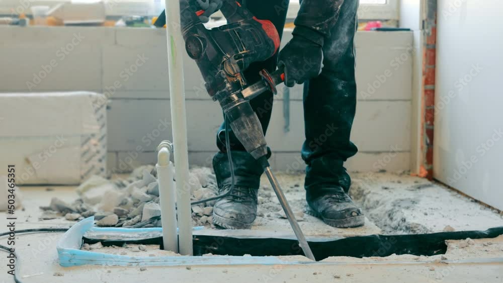 Construction and repair in a room or house. electric tools for breaking the concrete cover. The master breaks the concrete with a bumper.