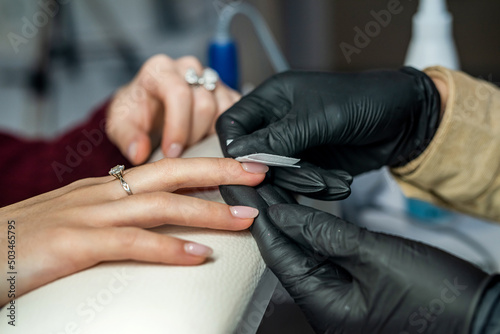 beautician doing manicure female customer in nail salon
