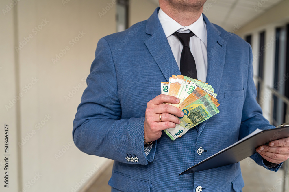 Hands of handsome businessman man in suit with euro banknotes in hands on business office. Hands of handsome businessman man in suit with euro banknotes in hands on business office.
