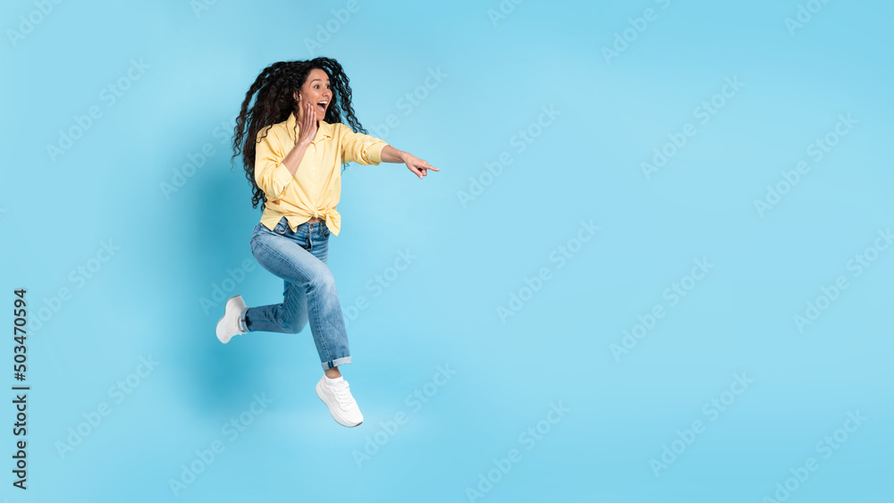 Excited woman pointing finger aside at copy space Excited woman pointing finger aside at copy space