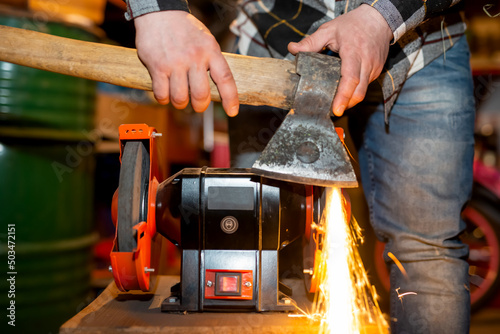 The process of sharpening an ax with the release of a large number of bright sparks photo