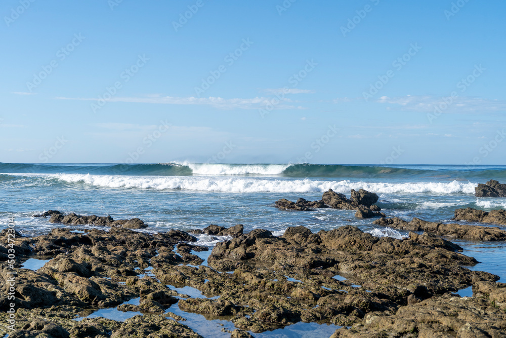 Perfect wave over the rocks at beautiful beach Playa Hermosa. Surfing in Santa Teresa, Costa Rica. Perfect wave over the rocks at beautiful beach Playa Hermosa. Surfing in Santa Teresa, Costa Rica.